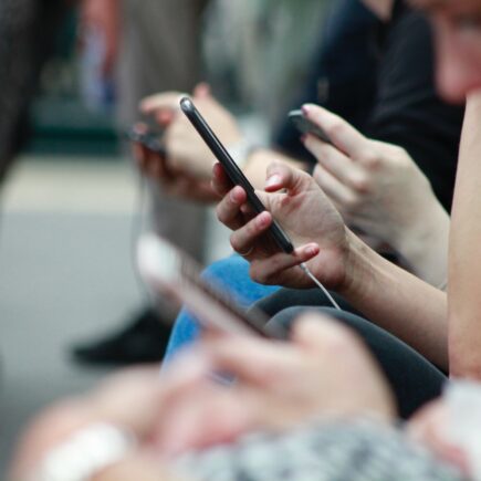 people on phones sitting in line